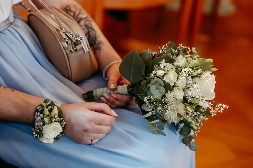 Eine Person hält einen Blumenstrauß.